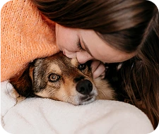 Dueña abrazando y consolando a perro durante eutanasia domiciliaria